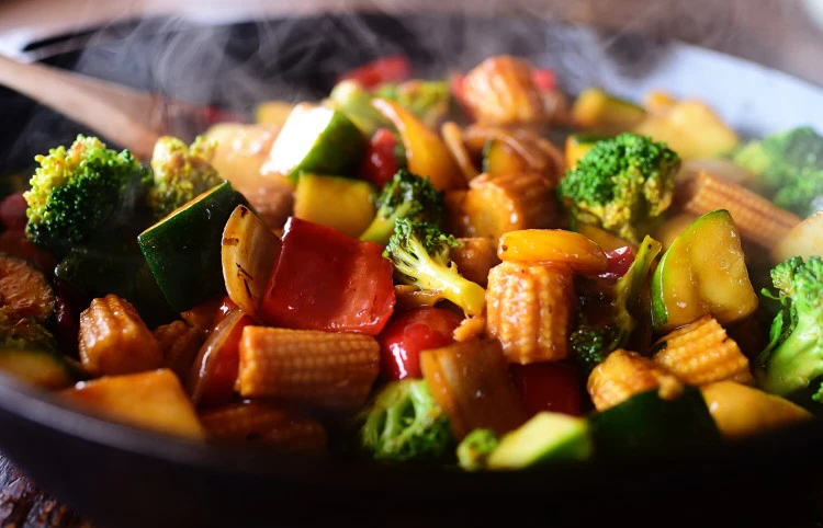 Colorful veggie stir-fry in a wok with broccoli, peppers, and zucchini.